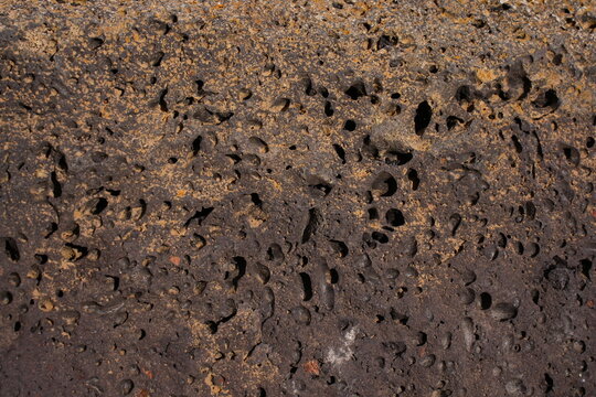 Primer plano de piedra volc&aacute;nica porosa con textura de burbujas de gas y malpa&iacute;s.