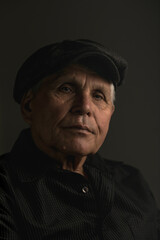 Obraz premium Portrait of an Elderly Man in a Cap Looking Up with Hope