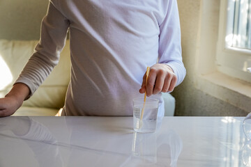 Hands Mixing Liquid in Measuring Cup with Spoon