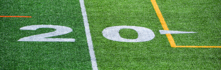 The 20-yard-line of an american football field with artificial turf