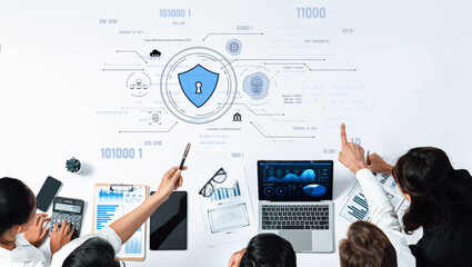 A diverse team of professionals collaborates on cybersecurity strategies using digital tools and data analysis in a modern office environment to enhance security. Trope