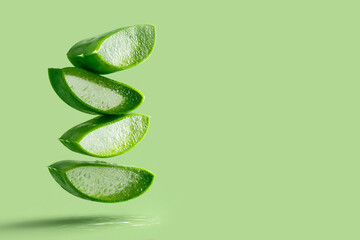 Fresh aloe levitation concept on green background for beauty product visuals.