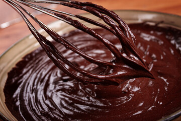 a bowl of chocolate dough, a whisk for whipping, baking, structure and consistency, homemade, top view, no people,