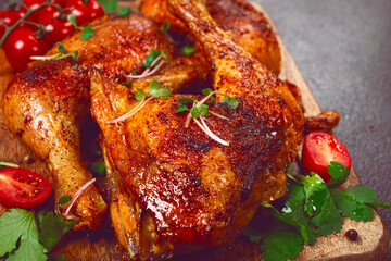 grilled fried chicken legs, served with fresh cherry tomatoes, and herbs, on a wooden chopping board, homemade, no people,