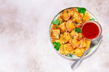 fried ravioli with parmesan cheese, served with red sauce and garnished with herbs, on a light background, no people,