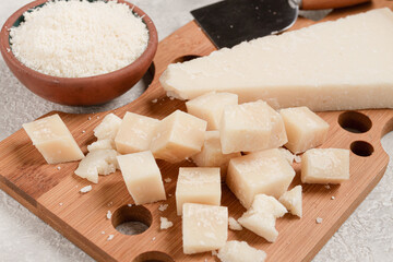 Freshly sliced and grated cheese, parmesan cheese, on a wooden chopping board, rustic style, no people