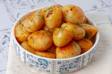 Baked new potatoes, with butter and dill, on a white plate, at home, no people,