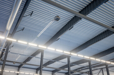 Obraz premium Industrial Ceiling with Metal Beams, Ventilation Ducts, and Fluorescent Lighting