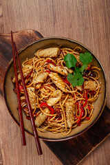 udon noodles, with squid and vegetables, on a wooden table, homemade, no people,