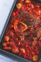 ossobuco stew with vegetables, knuckle on the bone with new potatoes, in tomato sauce,homemade, top view, no people,