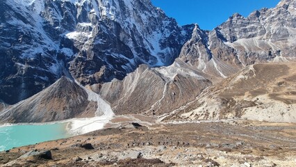 Breathtaking panoramic view of a turquoise glacial lake nestled among towering snow-capped...