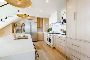 Large kitchen dining room interior white marble countertops brass light fixtures modern oven and stainless steel appliance ocean view floor to ceiling windows hardwood floor modern spacious design © Sheila