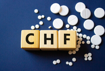 CHF symbol. Wooden cubes with words CHF Congestive Heart Failure. Beautiful deep blue background....
