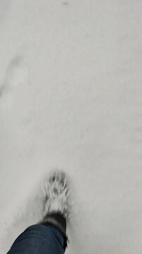 Frau stapft in Winterstiefeln durch den Schnee 