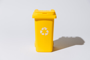 Yellow recycling bin with eco-friendly symbol on white background