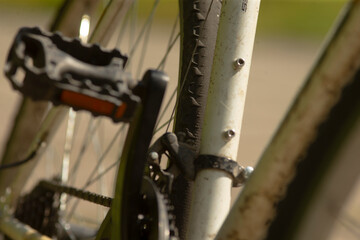 Closeup bicycle crank and chainstay showing grease and wear, metal teeth and sprocket details,...