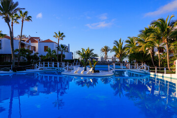 Hotel resort panorama with swimming pool, bridge and palm trees in Playa de las Americas, Tenerife
