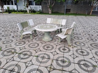 Round white marble garden table with stone stools in outdoor patio
