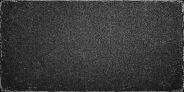 A dark macro shot of a rough black leather material texture featuring a grunge pattern surface that resembles a grey asphalt road backdrop for a textured textile wallpaper design