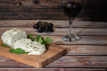 Slices of cyprus halloumi cheese red wine and grapes on wooden board