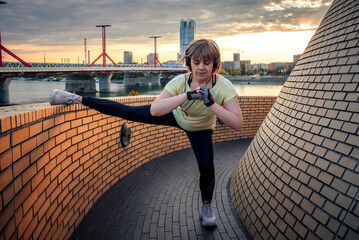 Young woman stretches on the roof
