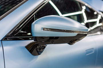 Car side mirror with integrated camera blue car, cam for driver safety and visibility. Car side view camera system integrated into rearview mirror, blind spot detection, 360 visibility. Camera 360. 
