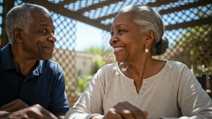 Happy senior African American couple enjoys a game of checkers outdoors on a sunny day. Relaxed retirement lifestyle, spending quality time together. Playful moments and companionship.