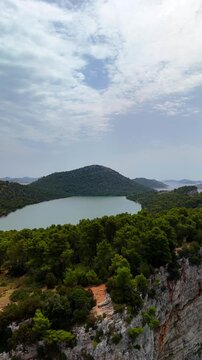 Vertical aerial drone view of Tela&scaron;ćica Nature Park and the stunning Slano Jezero salt lake on the Adriatic coast of Croatia. People enjoying the view. 