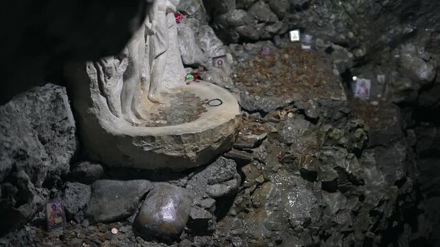 Water tap coing fountain in underground cave Devil's Throat (Dyavolsko garlo ) cave in the Rhodope Mountains, abundantly overgrown with deciduous and evergreen forest Trigradskoto Zhdrelo, Bulgaria