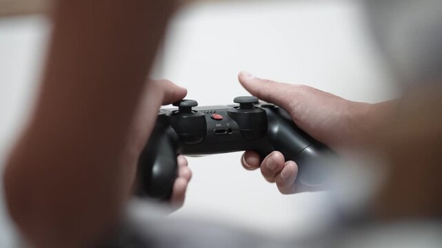 POV boy playing video game with wireless controller in living room