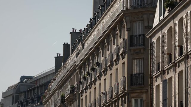 Panning shot of Parisian architecture featuring building facades with balconies and shutters The clip showcases a European cityscape ideal for travel destinations romantic getaways and urban lifestyle