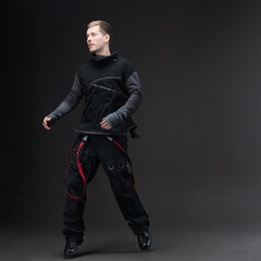 Male model in oversized techno-style outfit, studio portrait on neutral gray