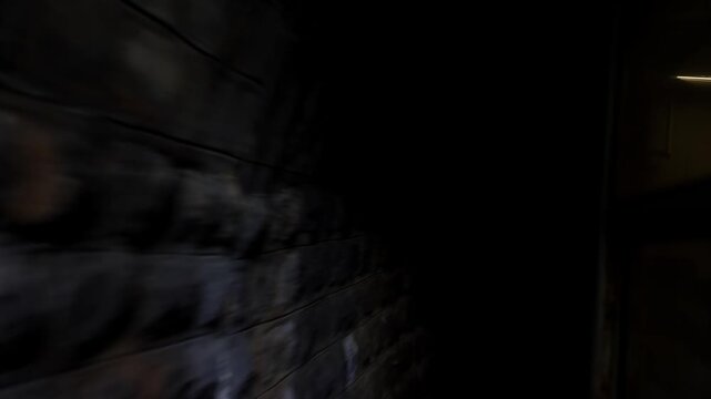 POV view from train window on railroad track entering a narrow mountian tunnel