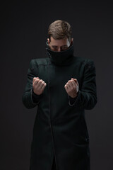 Cyberpunk portrait: man in high-neck coat concealing face, gloomy future aesthetic.