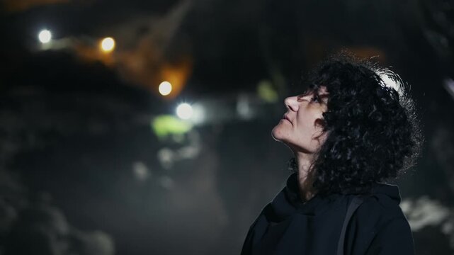 Woman visiting mystic view underground cave Devil's Throat (Dyavolsko garlo ) cave in the Rhodope Mountains, abundantly overgrown with deciduous and evergreen forest