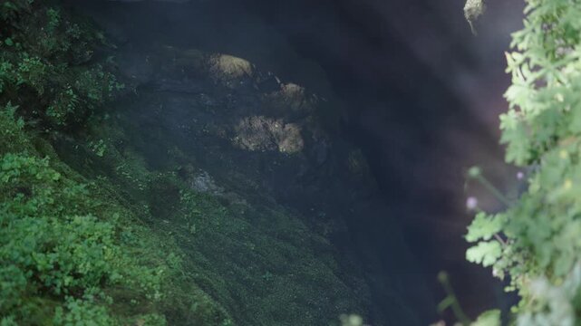 Fog and sunrays from mystic underground cave Devil's Throat (Dyavolsko garlo ) cave in the Rhodope Mountains, in Trigradskoto Zhdrelo, Bulgaria
