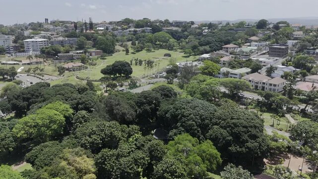 Drone flies over Mitchell Park toward Jameson Park on sunny day in Morningside neighborhood in Durban, South Africa