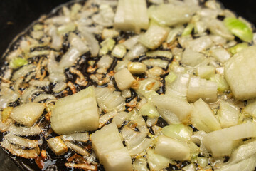 Sauting onions and celery in a skillet for a cooking preparation