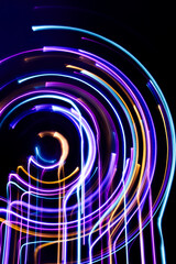 A long exposure photograph. Light painting photography, vibrant fairy lights against a black background