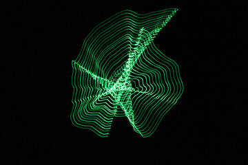 A long exposure photograph. Light painting photography, vibrant green fairy lights in a wormhole star effect against a black background