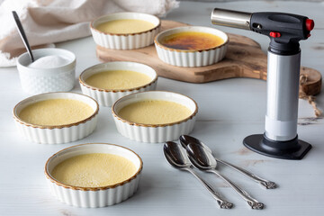 Ramekins of homemade Creme Brulee ready for torching sugar on top.