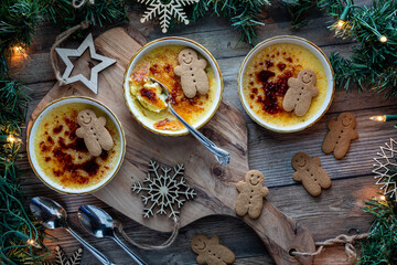 Delicious Creme Brulee in wide ramekins served with little gingerbread cookies.