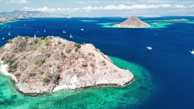 Drone perspective of Pulau Kelor Komodo surrounded by tropical ocean and lush coastline