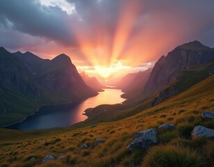 Vast mountain valley lake reflects sunset sky rays. Green grassy slopes and rocky peaks surround calm water. Dramatic clouds frame horizon with bright sunbeams.
