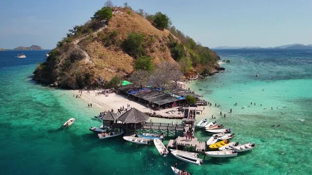 Aerial view of Pulau Kelor in Komodo National Park with snorkelers swimming near small sharks