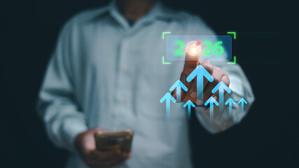 Future business growth concept. A man touching virtual target 2026 and upward arrows. Strategic planning, success goals, digital transformation, investment growth. Business vision for the coming year.