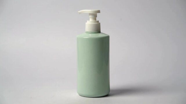 A minimalist light green pump bottle, ideal for cosmetic or hygiene product packaging mockups and ads.