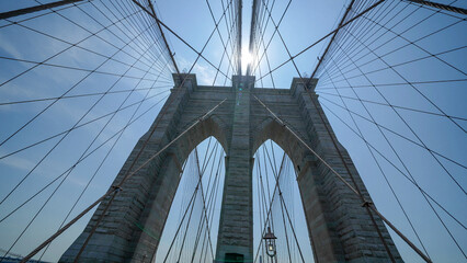 Obraz premium Brooklyn Bridge stone pillars captured from below highlighting structural details and grandeur