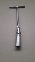 Fototapeta premium motorcycle spark plug wrench made of stainless steel with a gray background. background concept of spare parts, repair, maintenance, transport, transportation, tool, mechanic, motorcycle, safety