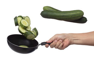 Cucumber fly fall in pan, green fresh vegetable cucumber cut chop slice. Organic fresh vegetable with eaten leaf of long cucumber, close up texture. White background isolated freeze motion high speed